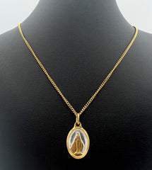 Adorno de oro fino compuesto por Medalla Milagrosa ovalada de 20 mm, fondo de esmalte epoxi blanco y cadena de 45 cm.