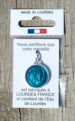 Médaille Apparition de Lourdes, aluminium, ronde 17,5 mm, émaillée et facettée, contenant de l'eau de Lourdes